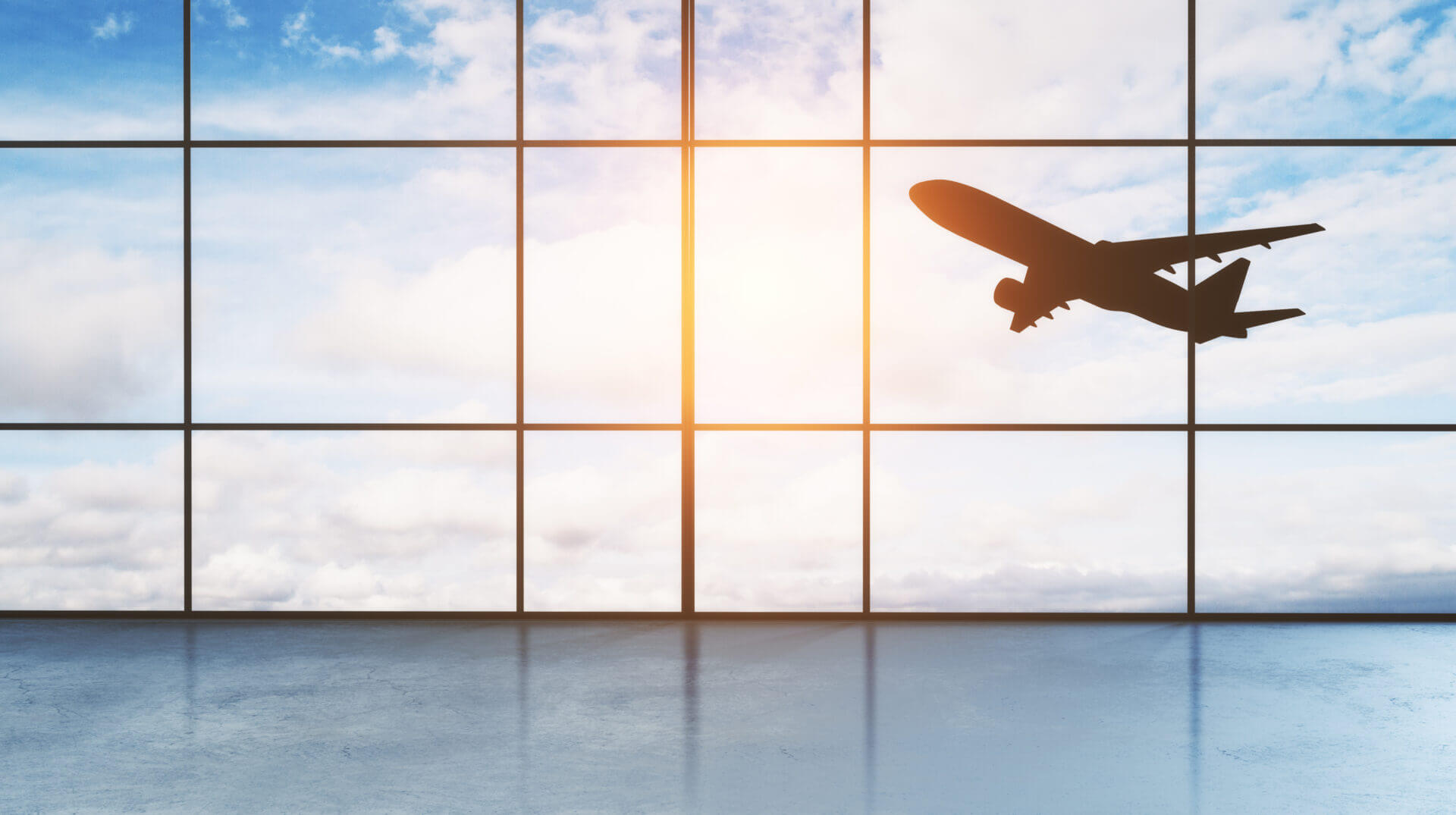Picture of a take off aircraft behind airport window